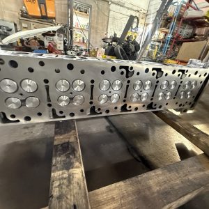 Rebuilt Detroit DD15 cylinder head at PPPTR, showing the machined deck and valves